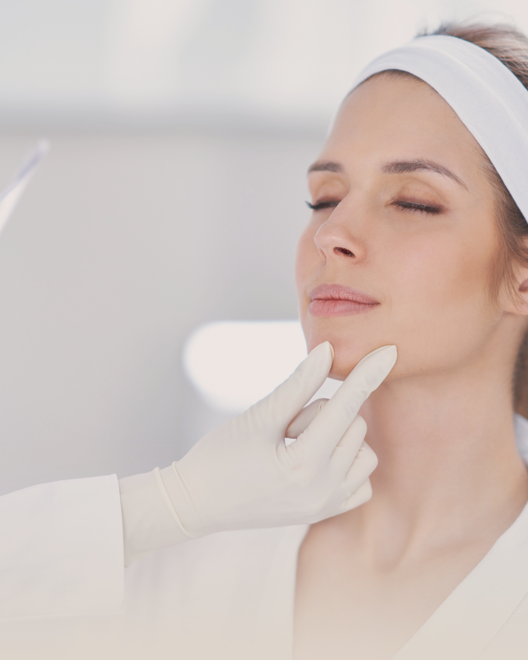Woman in a spa setting and gloved hand holding her face