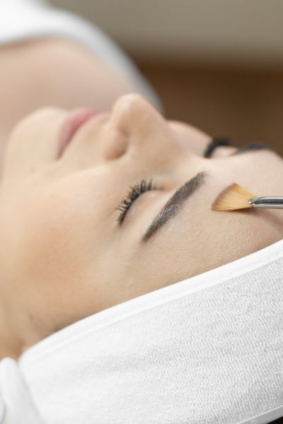 Woman getting a chemical peel in a spa setting.